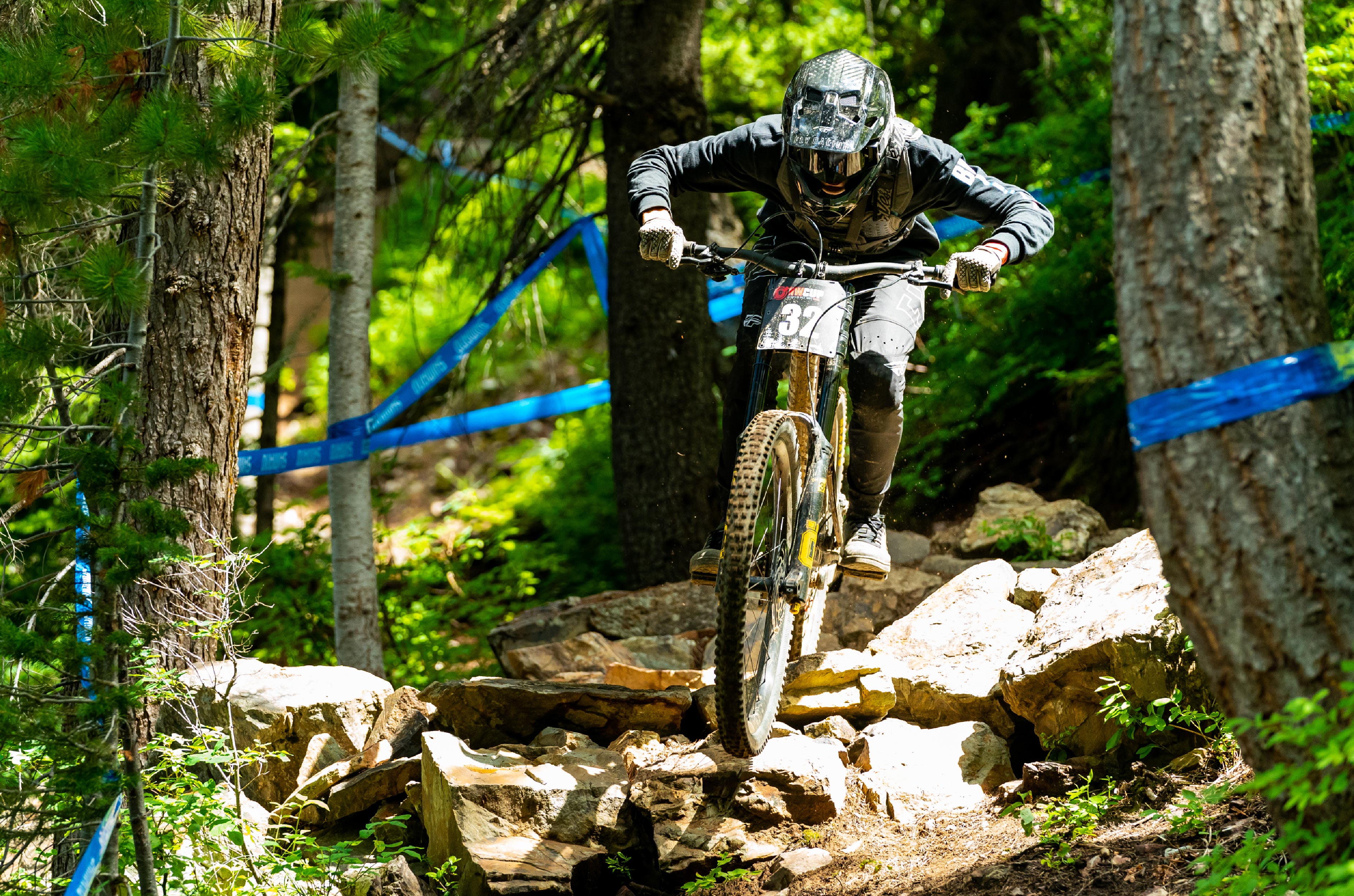Mountain biker racing through a tight trail